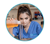 lab student measures liquid chemicals into a beaker