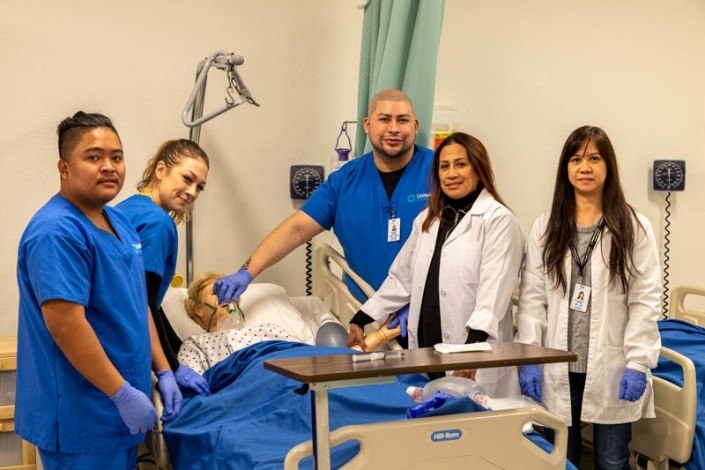 Students practicing using an oxygen mask on a simulation mannequin