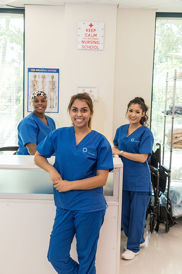 Three nursing students in blue scrubs