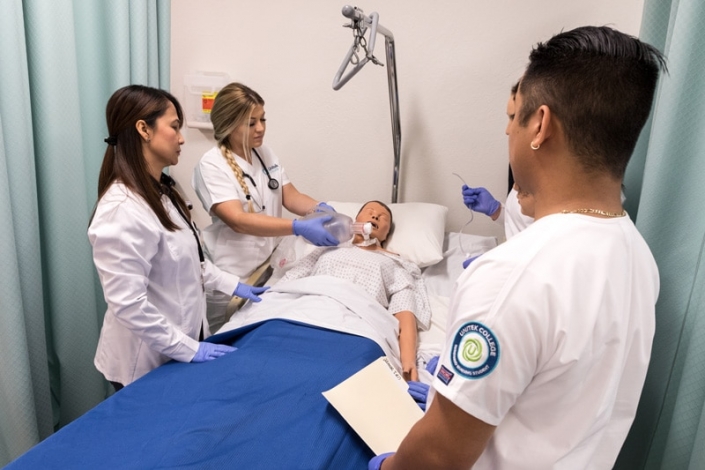 Nursing students practicing nursing skills on a simulation mannequin