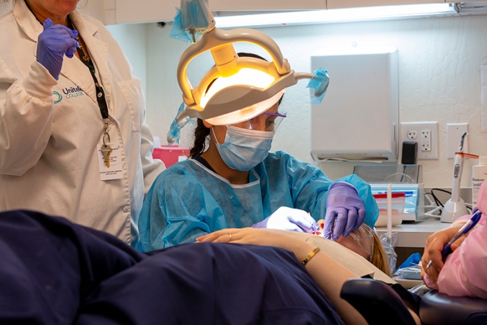 Estudiante de asistente dental practicando con un paciente real.
