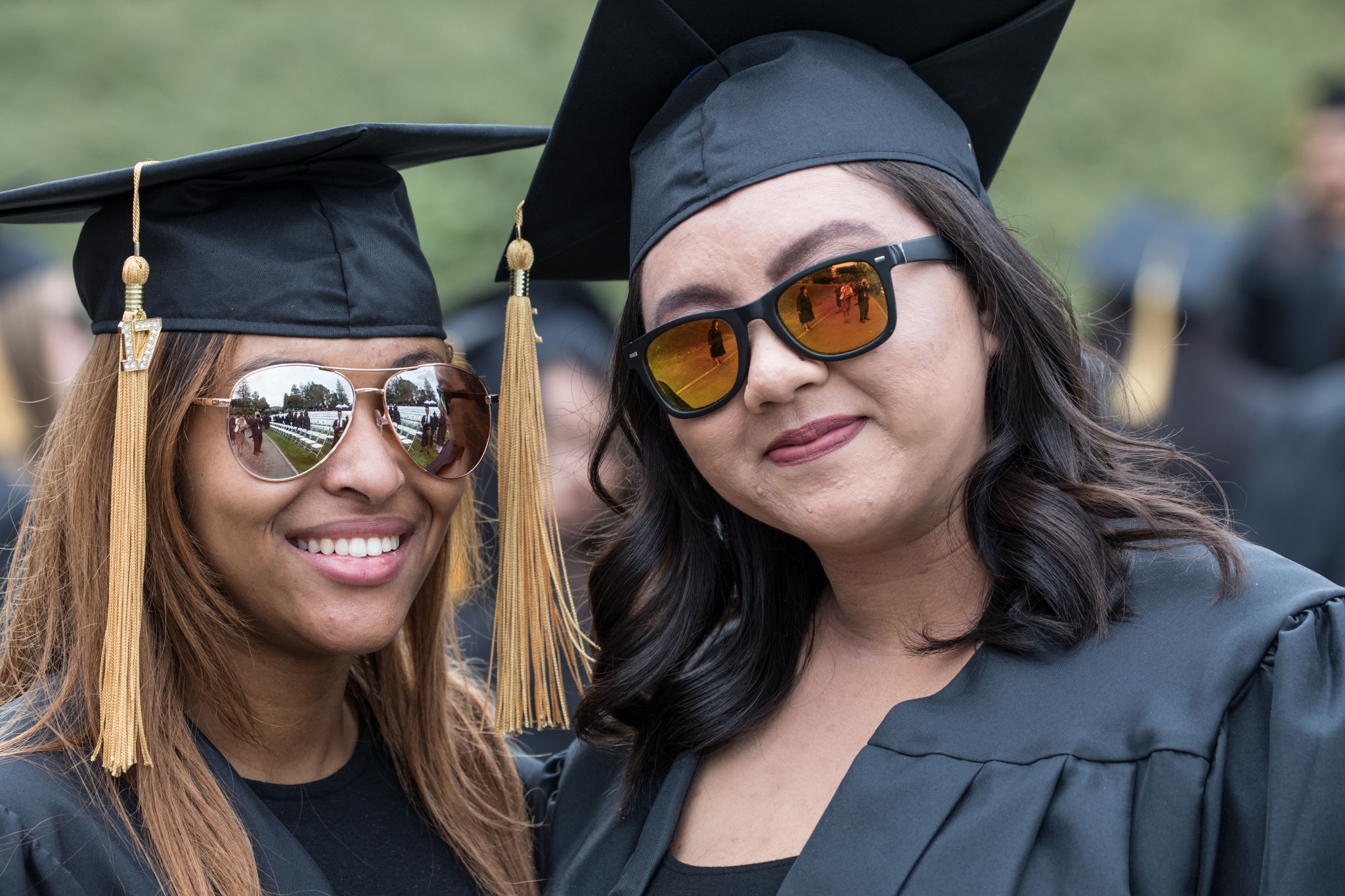 Smiling female graduates in gowns and caps