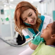 Smiling professional assisting with a dental exam