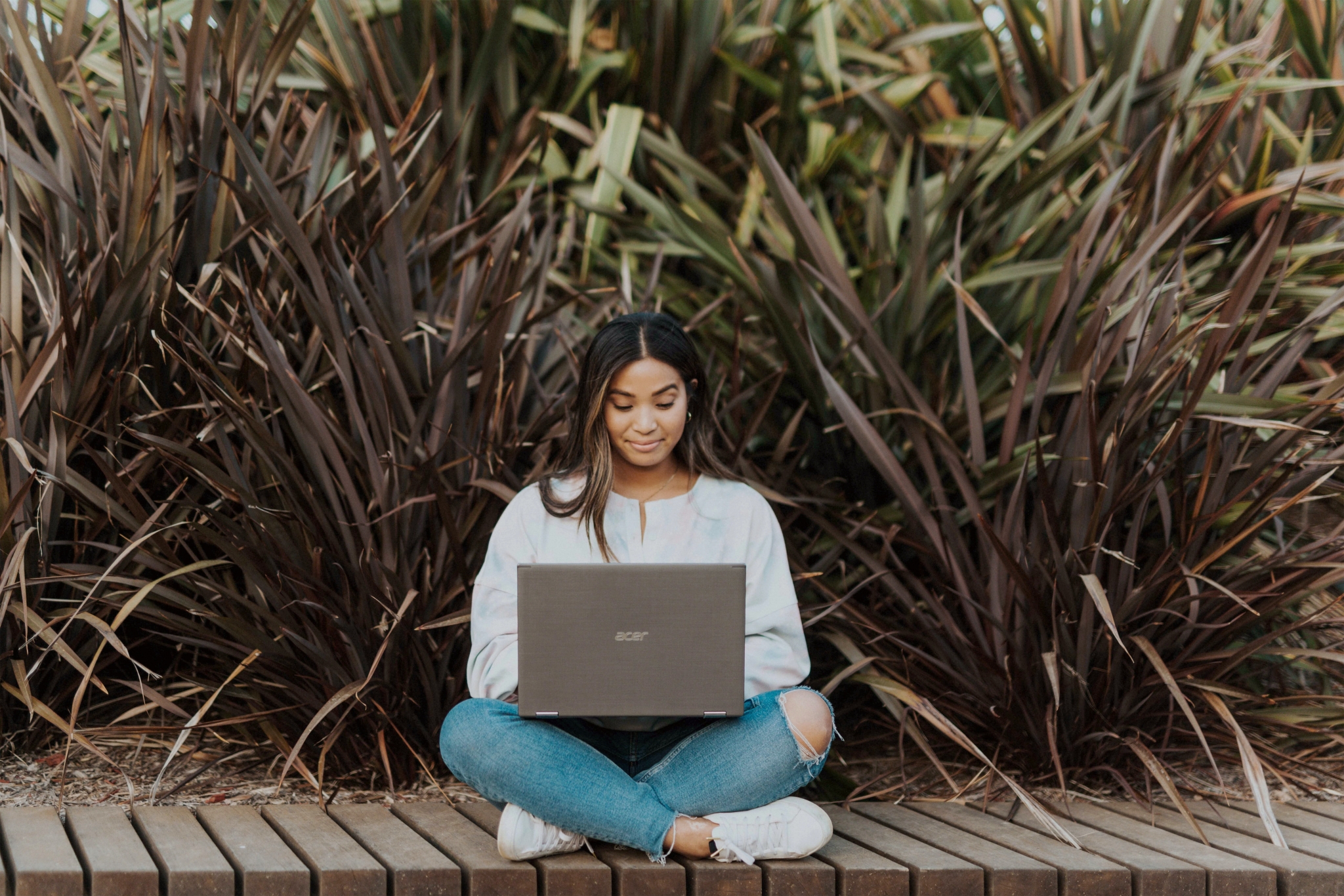 Woman outside on a laptop.