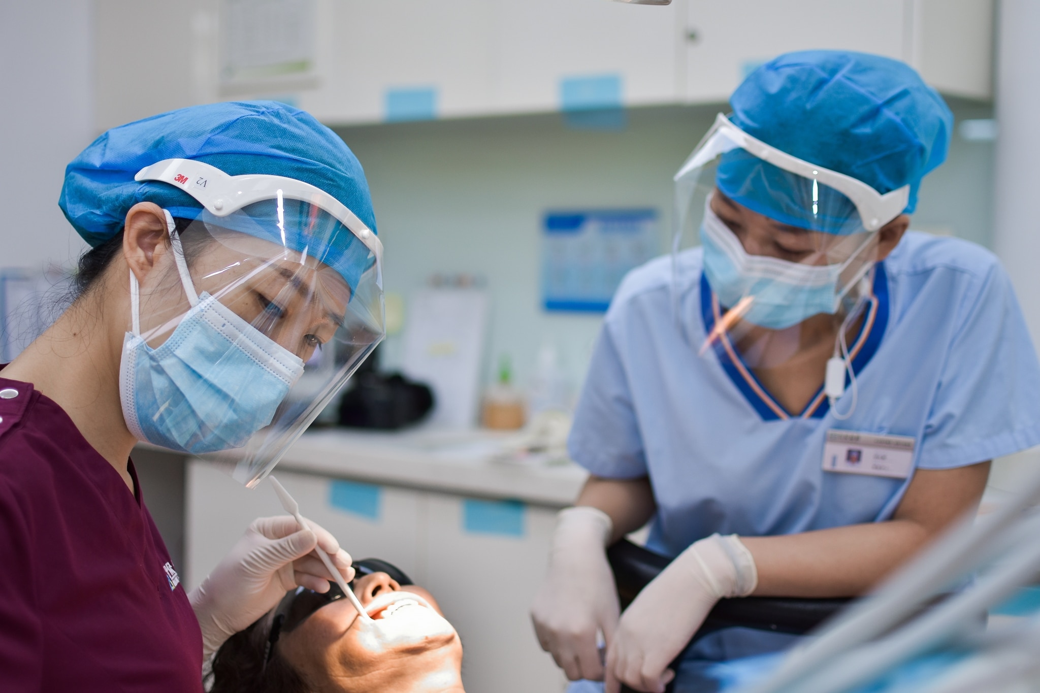 Masked dental team examining a patient