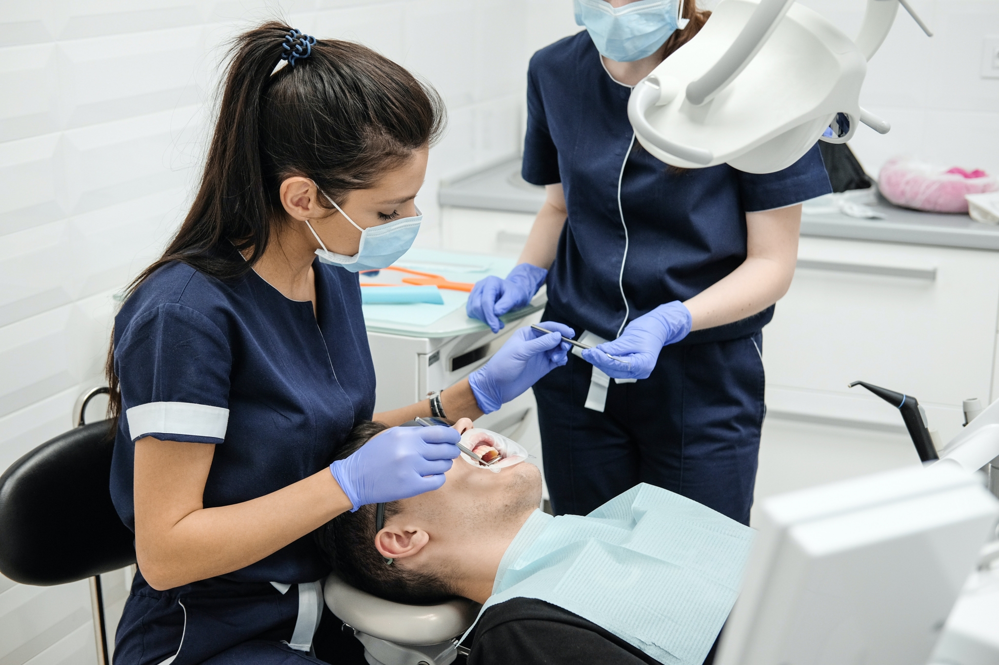 Dental Hygienist and Dental Assistant examining a patient