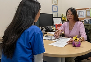 Nursing student sitting with administrator at a desk