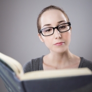 Mujer con gafas leyendo un libro