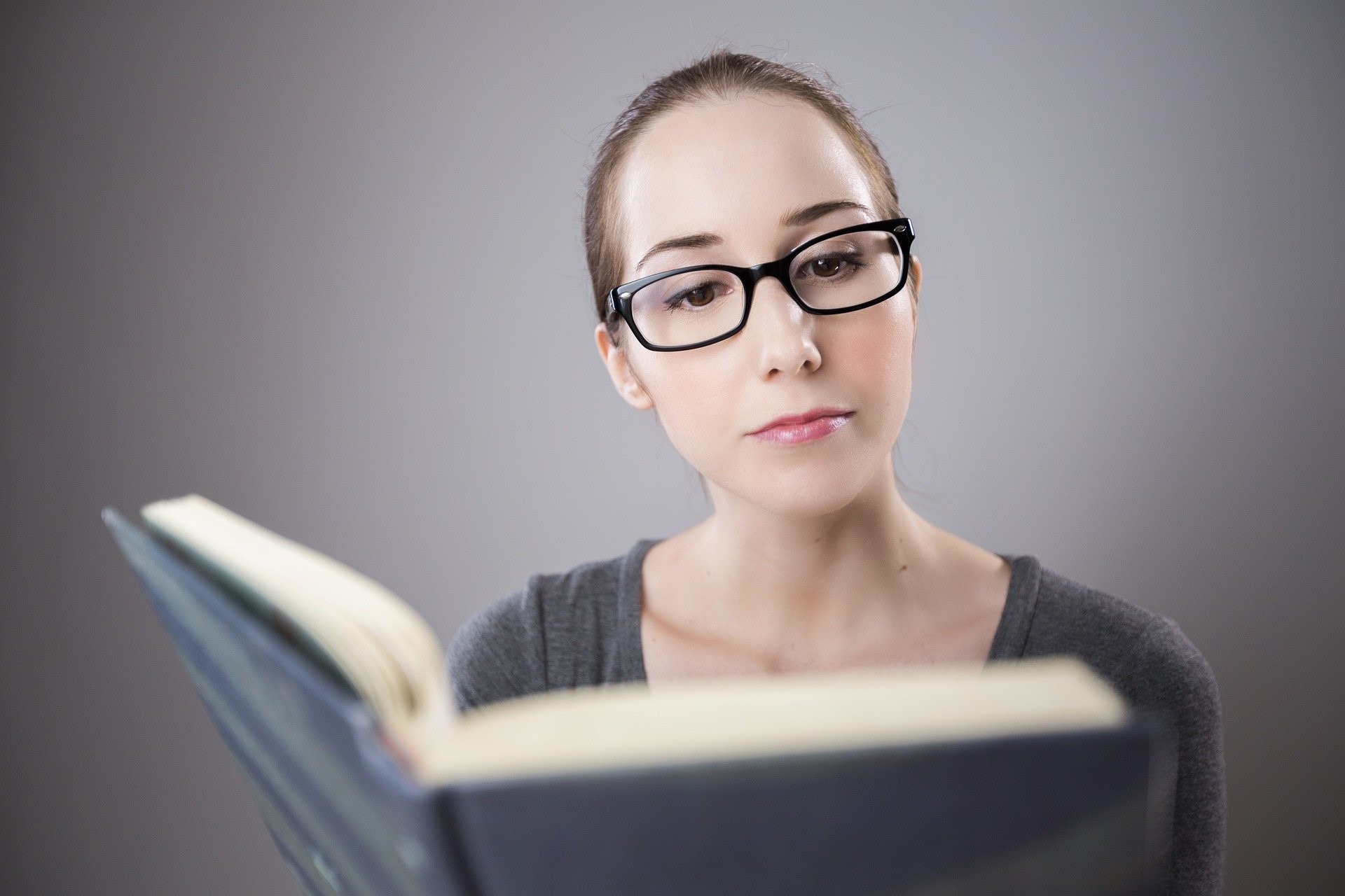 Mujer con gafas leyendo un libro