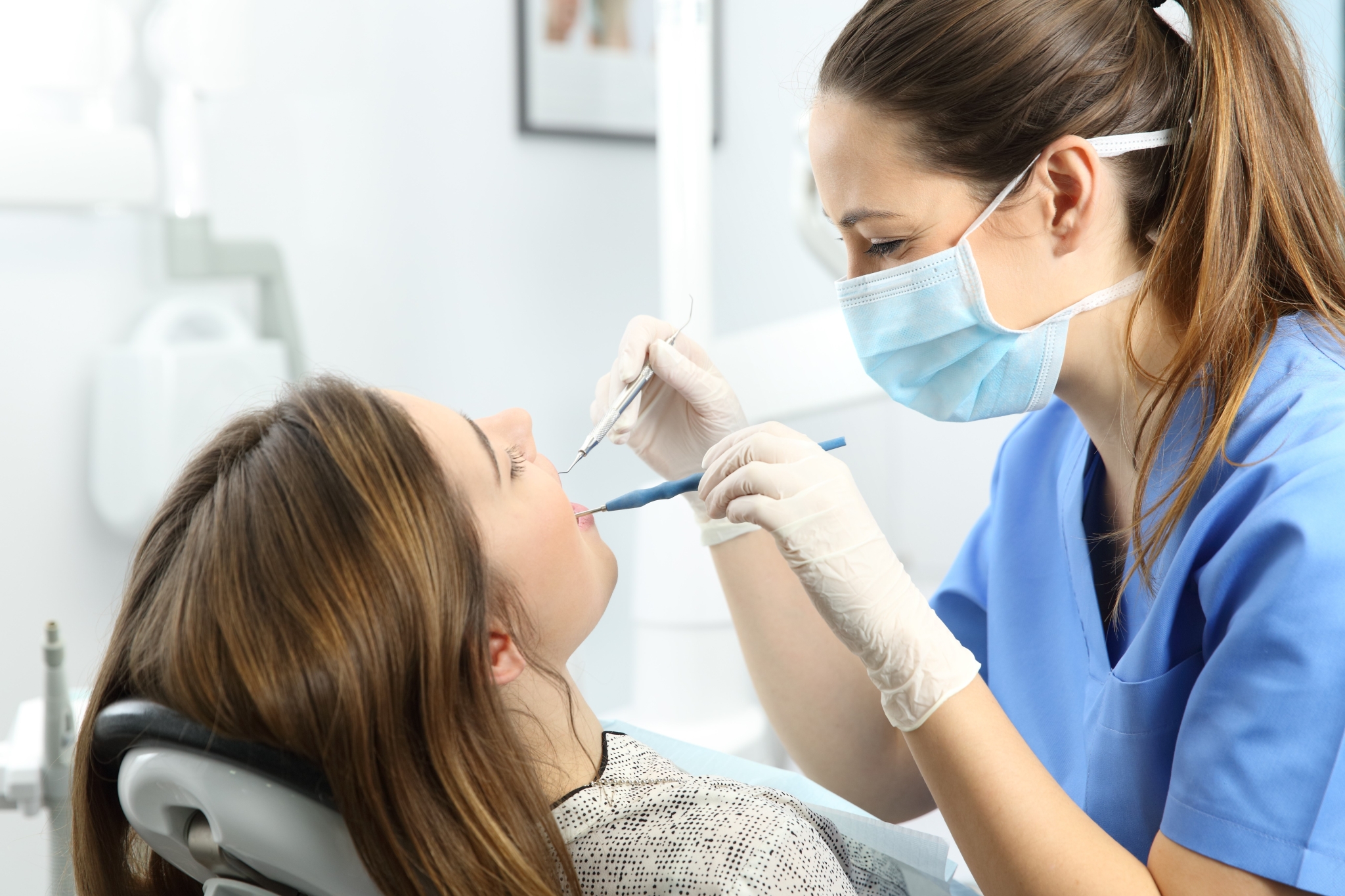 Dental professional examining a woman's mouth