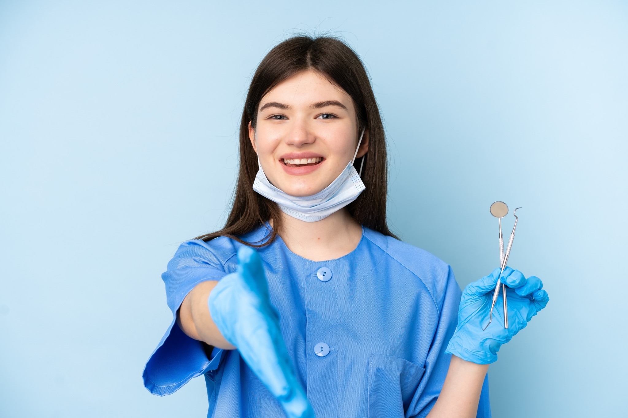 Young dental practitioner holding tools