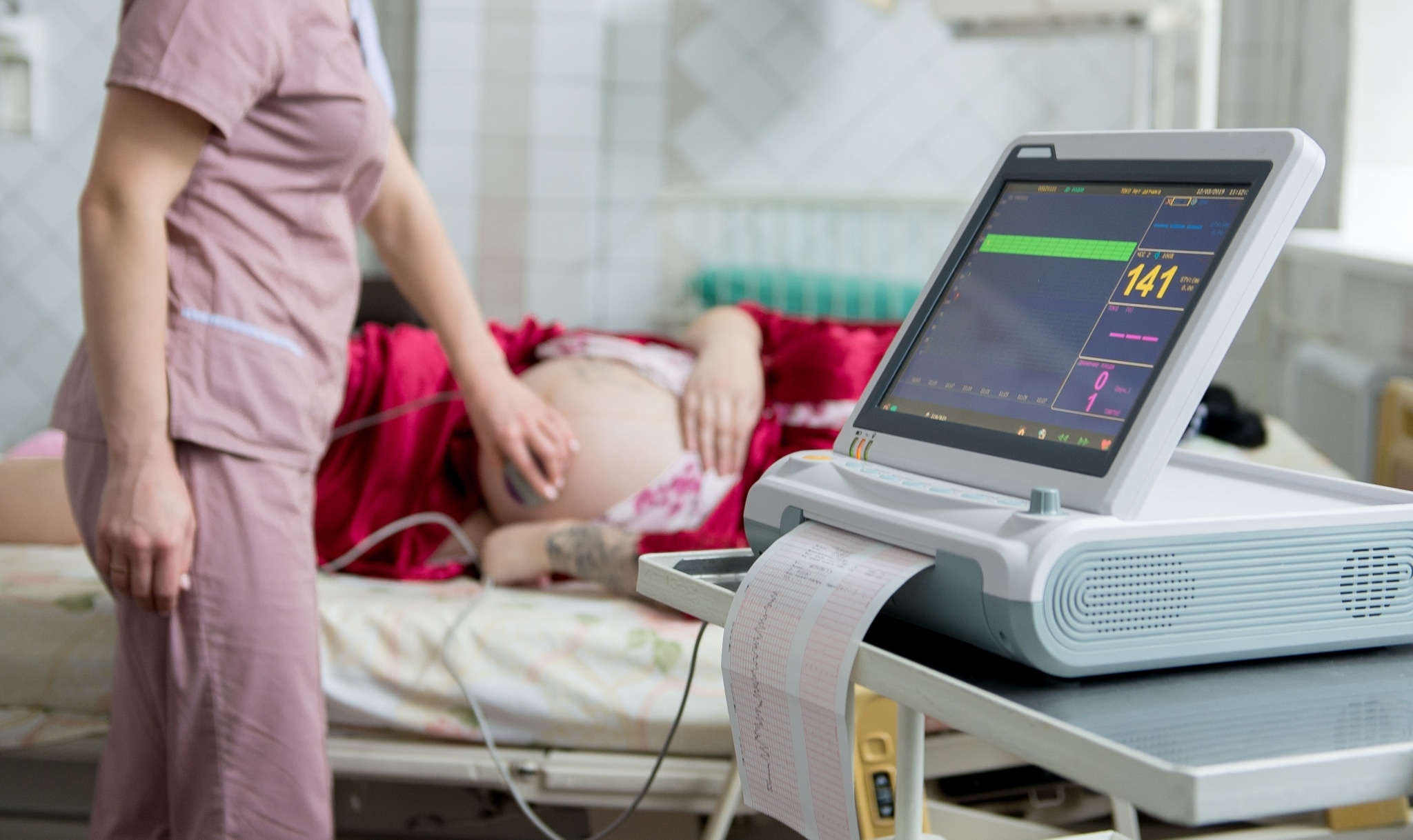Mujer embarazada con un electrocardiógrafo