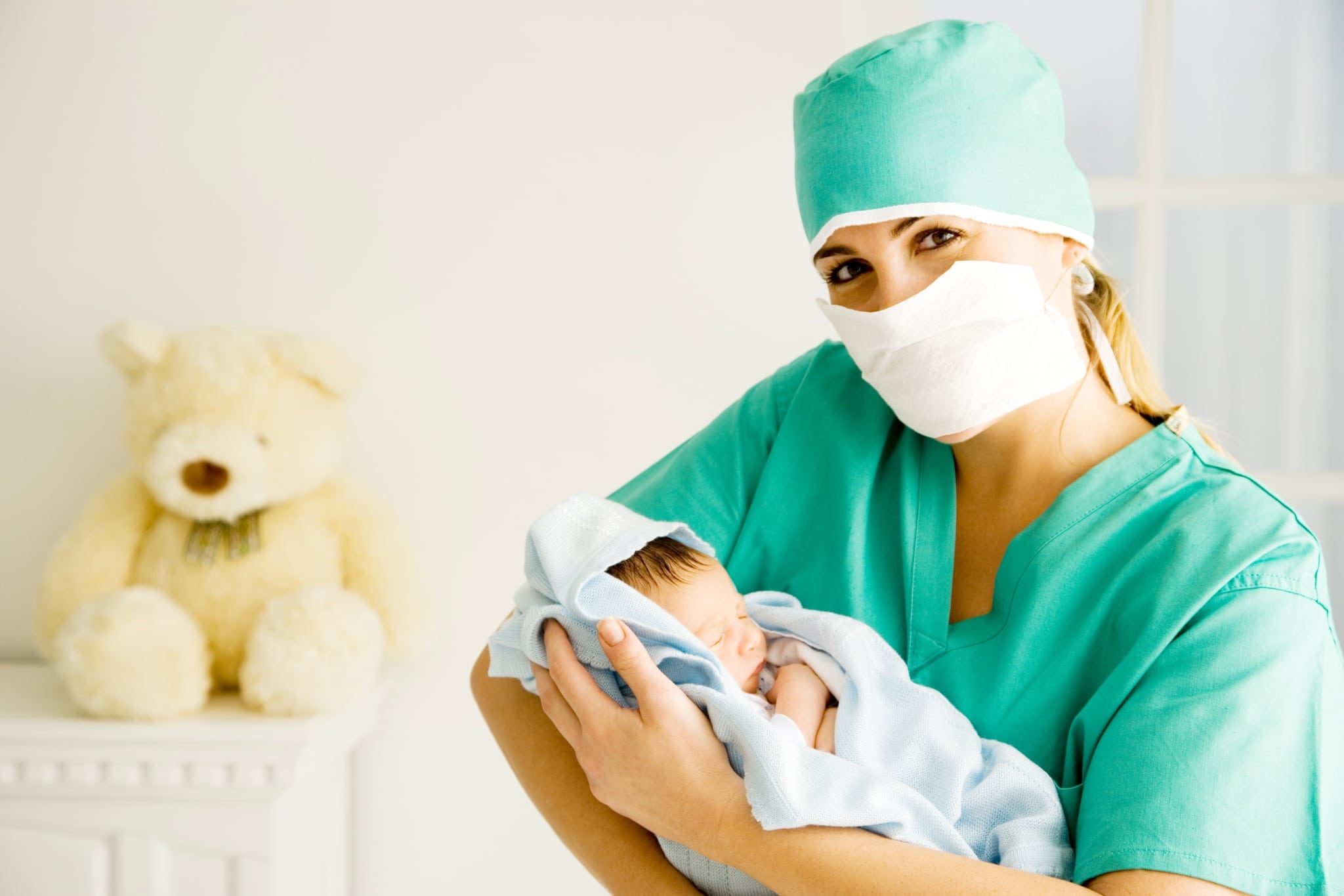 A smiling nurse holding a newborn