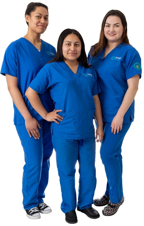Three nursing students in blue scrubs