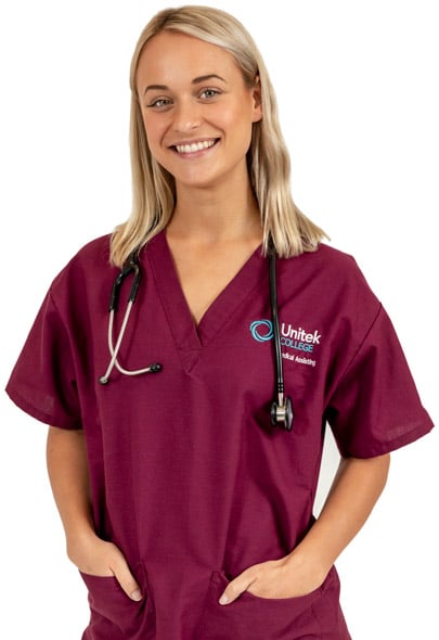 A student in maroon scrubs standing with hands in her pockets