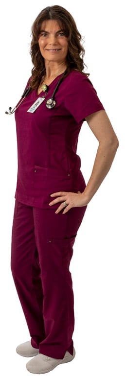 A nursing student in maroon scrubs standing with hands on her hips