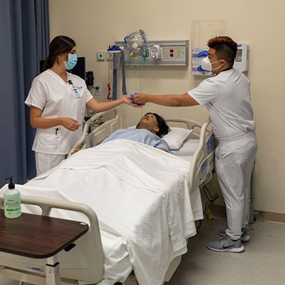 Two nursing students working in the simulation lab