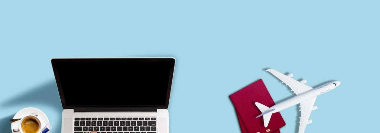 Travel nurse on a laptop with stethoscope and replica airplane