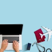 Travel nurse on a laptop with stethoscope and replica airplane