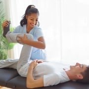 Smiling physical therapist assistant with client