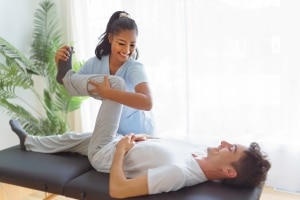Smiling physical therapist assistant with client