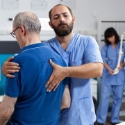 Male medical professional assisting a patient