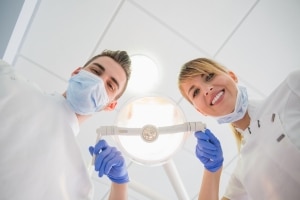 Dental team looking down at their patient