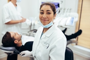 Smiling dental professionals with a patient in an exam room