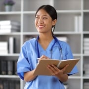 Profesional médico asiático sonriente tomando notas
