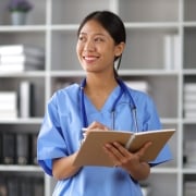 Smiling Asian medical professional taking notes