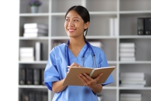 Profesional médico asiático sonriente tomando notas