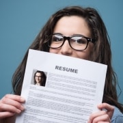 Close up of a woman in glasses holding her resume