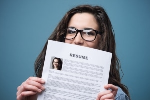 Close up of a woman in glasses holding her resume