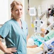 Blonde nurse standing next to an intubated patient