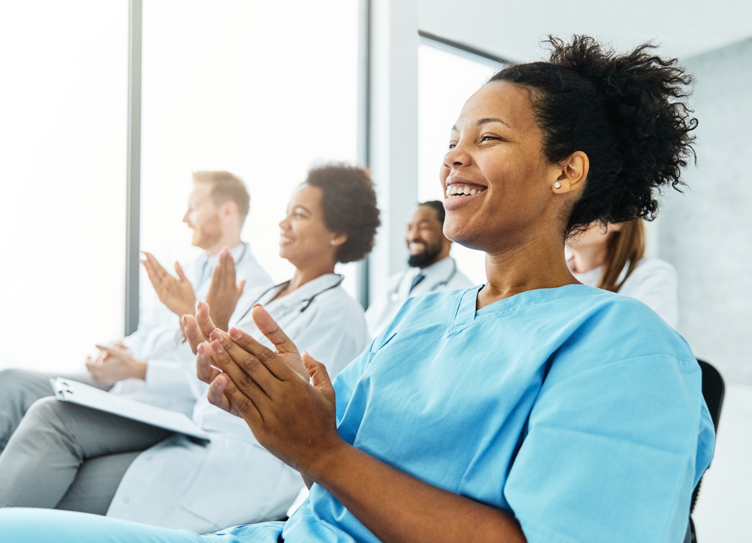African-American nurse clapping with colleagues