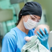 Neonatal nurse holding a newborn baby