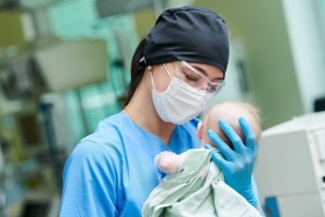 Enfermera neonatal sosteniendo a un bebé recién nacido