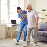 Nurse helping an elderly man walk