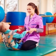 Physical therapy professional working with a child who has a disability