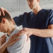 Physical therapy professional examining a man