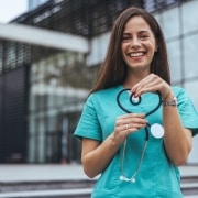 Joyful nurse forming a heart with her stethoscope